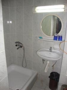uma casa de banho com um lavatório, um espelho e uma banheira em B&B Inex Negotin em Negotin