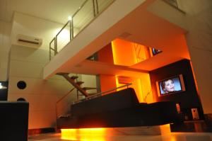 uma sala de estar com uma escada e uma televisão em Palace Motel (Adult Only) em Fortaleza