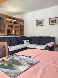 ポッツァ・ディ・ファッサにあるAppartamento Pradelのリビングルーム(青いソファ、テーブル付)