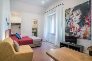 a hotel room with a bed and a painting on the wall at Napoliamo Guest House in Naples