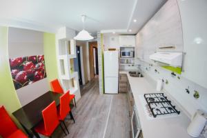 cocina con sillas de color naranja y nevera blanca en Apartment on Ion Neculce 1, ZityMall Shopping Center, Free Parking&WiFi en Chişinău