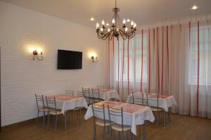 Pegas Club Hotel في تولا: غرفة طعام بها طاولات وكراسي وثريا