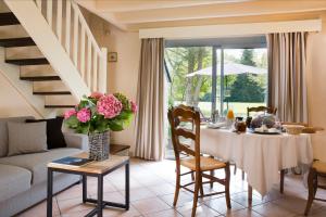 a living room with a table with a vase of flowers at Cottages De La Bretesche in Missillac