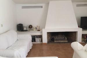 a living room with a white couch and a fireplace at Quinta da Balaia 3 Rooms in Albufeira