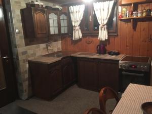 a kitchen with wooden cabinets and a sink at Planinska idila - uz stazu in Jahorina