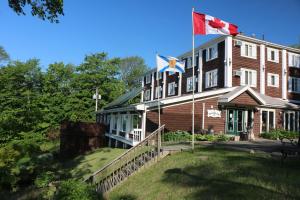 un grand bâtiment arborant un drapeau canadien sur lui dans l'établissement Braeside Country Inn, à Pictou