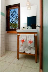 a bathroom with a sink and a mirror and towels at Mynt Retreat Bed & Breakfast in Montego Bay
