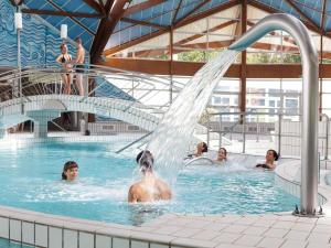 un grupo de personas en una piscina con una fuente en Hotel Restaurant De La Canner, en Kédange-sur-Canner