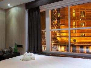 a bedroom with a window with a view of a city at The Z Hotel Soho in London