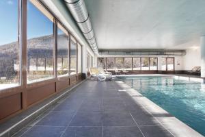 a swimming pool with a view of the mountains at Résidence Odalys Le Village de Praroustan in Pra-Loup