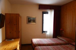 En eller flere senge i et værelse på Hotel Dolomiti