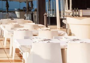 a group of white tables and white chairs at OLIVA HOLIDAYS 1 in Oliva