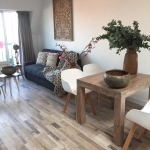 salon z niebieską kanapą i drewnianym stołem w obiekcie appartementen zeespiegel w Zandvoort