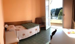 um quarto com uma cama e uma varanda em Centro di Spiritualità Maria Candida em Armeno