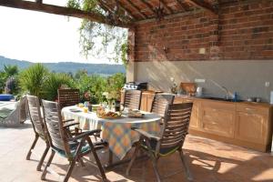 a table and chairs on a patio with a kitchen at Country Farmhouse with pool in Lascazères