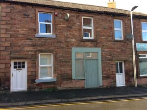 an old brick building with blue doors and windows at Brampton Holiday Cottage in Brampton