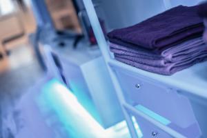 a glass shelf with a pile of purple towels on it at New designed Apartment in Vienna in Vienna