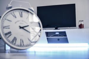 a clock sitting on a table next to a computer monitor at New designed Apartment in Vienna in Vienna