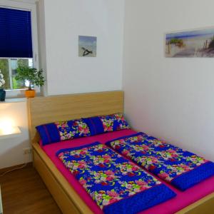 a bed with colorful sheets in a bedroom at Cochem Ferienwohnung Scheuer in Cochem