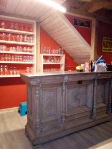 an old wooden bar in a room with glasses at Le Relais du Moulin in Gedinne