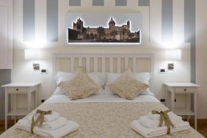 a bedroom with a bed with two towels on it at SUITE 188 - Via Roma in Palermo
