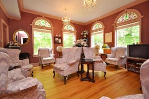 a living room with chairs and a table and a tv at Braeside Country Inn in Pictou