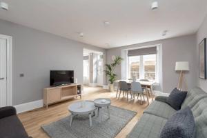 a living room with a couch and a table at ALTIDO Luxurious 2BR home near Haymarket station in Edinburgh