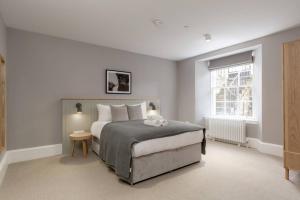 a bedroom with a large bed and a window at ALTIDO Luxurious 2BR home near Haymarket station in Edinburgh