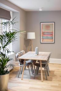 a dining room with a wooden table and chairs at ALTIDO Luxurious 2BR home near Haymarket station in Edinburgh