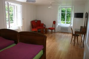 a living room with a couch and chairs and windows at Hôtel de la Truite in Champ-du-Moulin