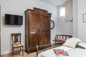 ボローニャにあるAbitaRoom Wine Mini-Flatのベッドルーム1室(大きな木製キャビネット、ベッド1台付)