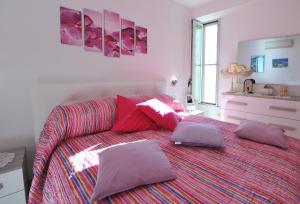 ein Schlafzimmer mit einem Bett mit lila Kissen darauf in der Unterkunft Casa Carola in Positano