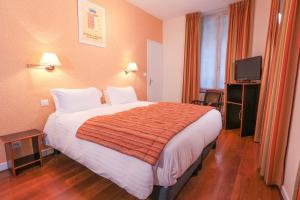 a hotel room with a large bed and a television at Hôtel Restaurant Des Remparts in Chaumont