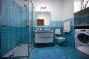 ein blaues Badezimmer mit einem Waschbecken und einer Waschmaschine in der Unterkunft Casa Carola in Positano