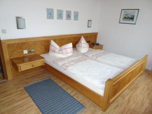 een bed met witte lakens en kussens in een kamer bij Gästehaus Eberle in Oberstaufen