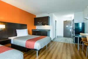 a small hotel room with two beds and a kitchen at Motel 6-Atlanta, GA - Atlanta Airport in Atlanta