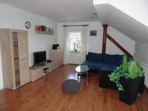 a living room with a blue couch and a tv at Gästehaus Eberle in Oberstaufen