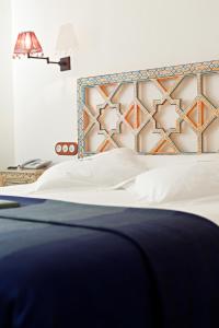 
a hotel room with a bed, nightstand, and nightstands at Alcoba del Rey de Sevilla in Seville
