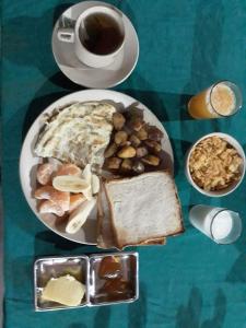 a table with a plate of breakfast food and a cup of coffee at Tiger Residency Resort in Sauraha