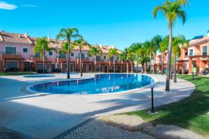 - une piscine dans une cour bordée de palmiers dans l'établissement Moradia Jardins do Vale, à Albufeira