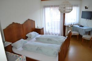 a bedroom with a bed and a table and a window at Gaestehaus Tagescafe Eckenfels in Ohlsbach