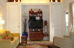 ein Wohnzimmer mit einem Sofa und einem TV in der Unterkunft Jingle Bells Square Cottage-Historic District-Bright- Fireplace in Savannah