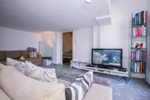 sala de estar con sofá y TV de pantalla plana en Riva di Faggeto Lario, en Faggeto Lario 