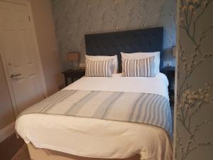 a bedroom with a large bed with a blue headboard at Hendford Apartments in Yeovil