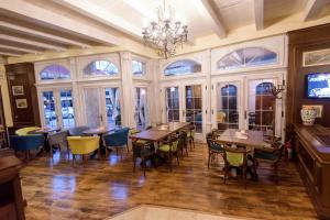 a dining room with tables and chairs and windows at Hotel Castel in Râmnicu Vâlcea