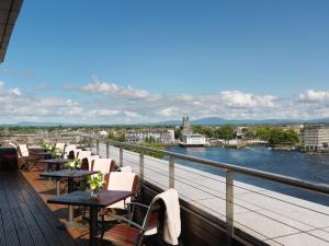 a row of tables and chairs on a balcony overlooking a river at Limerick Strand Hotel in Limerick