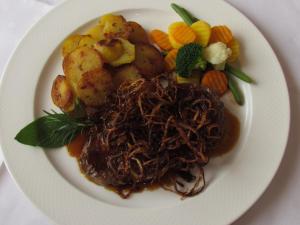 a plate of food with meat and potatoes and vegetables at Landhotel-Gasthof-Schreiner in Hohenau