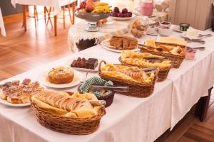 a table with baskets of bread and pastries on it at Pousada Pedra Preta in Urubici