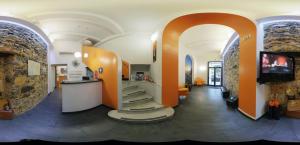 - un hall avec une télévision et des escaliers dans l'établissement Hotel Fiume, à Gênes