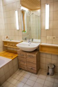 une salle de bain avec un lavabo, une baignoire et un miroir dans l'établissement FEWO Silberberg TOP 4, à Alpbach